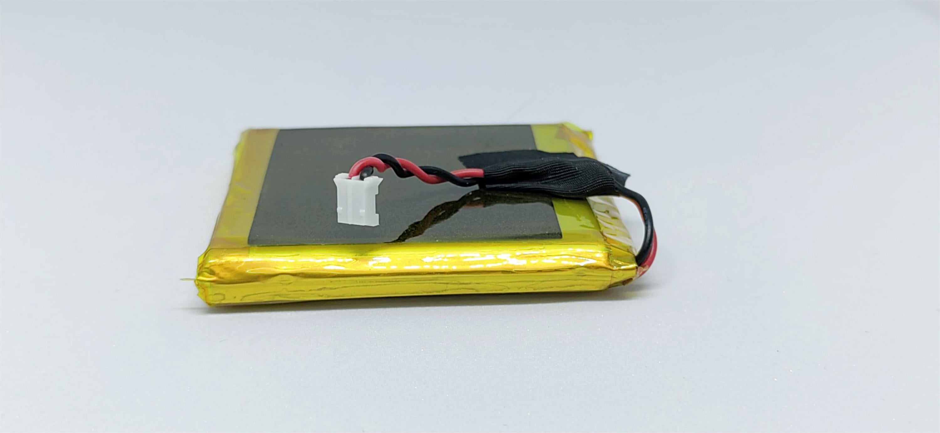 A yellow lithium polymer battery with red and black wires attached to it, presumably for a remote control device like a drone or a toy car.