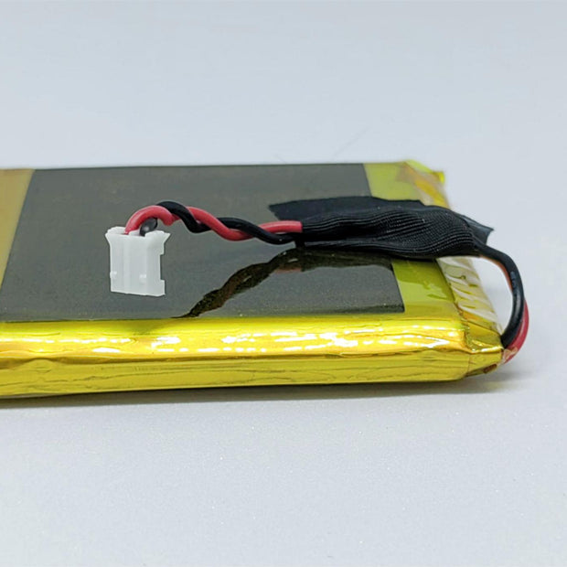 A yellow lithium polymer battery with red and black wires attached to it, presumably for a remote control device like a drone or a toy car.